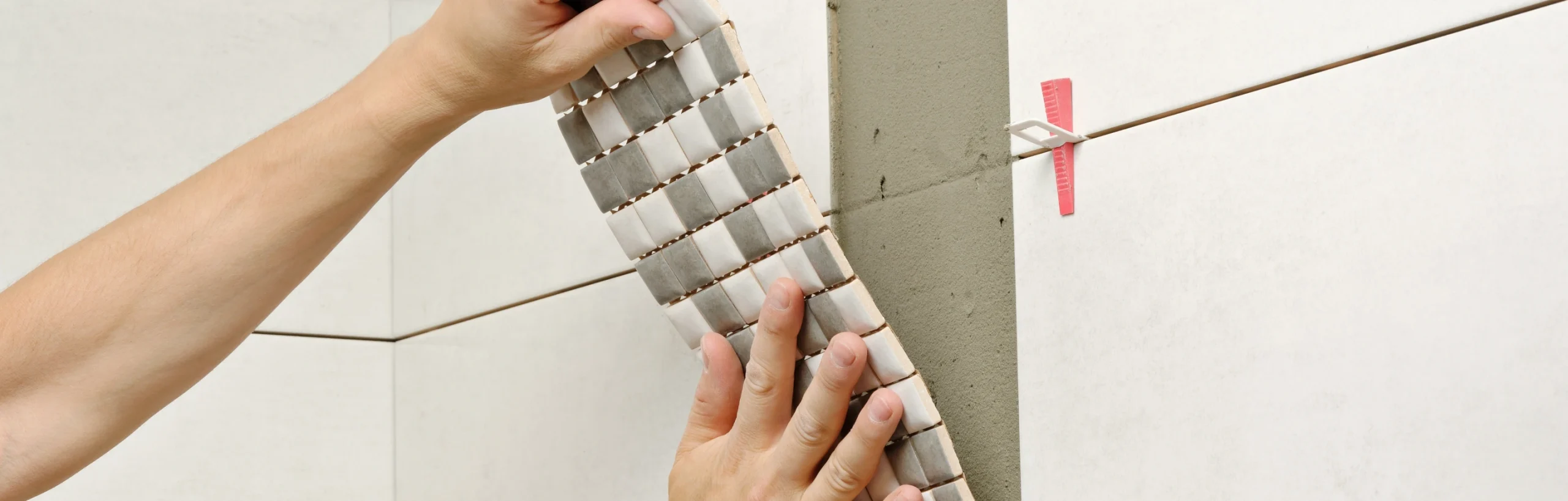 Händer som sätter mosaik på en vägg